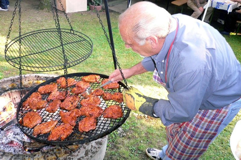 starszy pan grillujący mięso