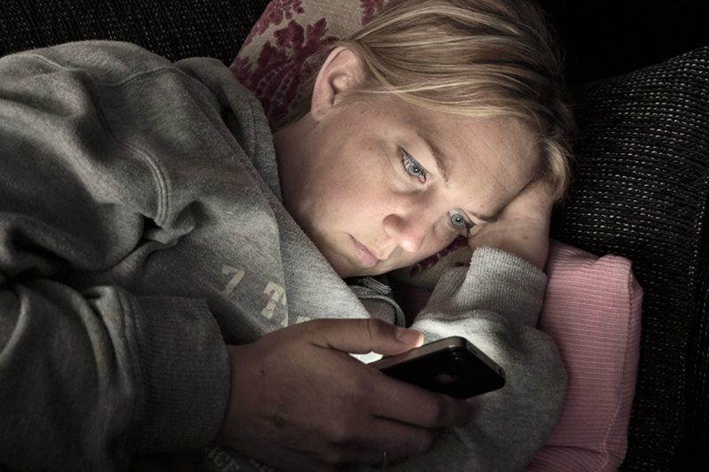 zmartwiona kobieta odczytująca wiadomość sms z telefonu