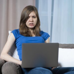 przestraszona dziewczyna trzymająca laptopa