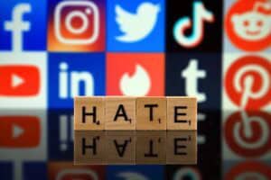 litery układające się w napis hate na tle ikon portali social media