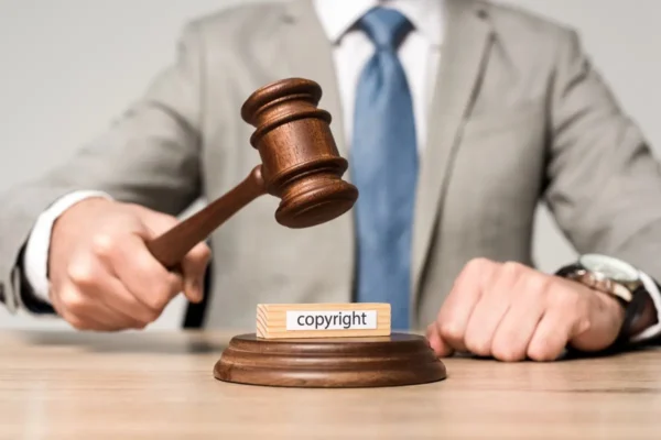 młotek sędziowski uderzający w podstawę z napisem copyright